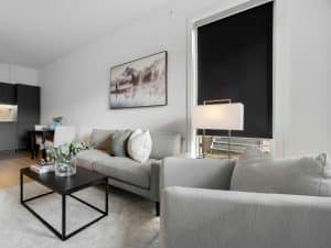 Contemporary living room with grey furniture and blockout roller blinds covering the window.