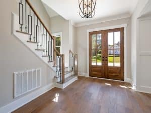Modern home entryway with timber doors and staircase, ideal for light-filtering not full blockout roller blinds.