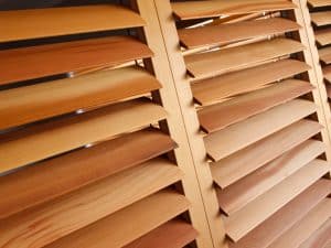 Display of timber samples showcasing the best material for plantation shutters in various wood finishes.