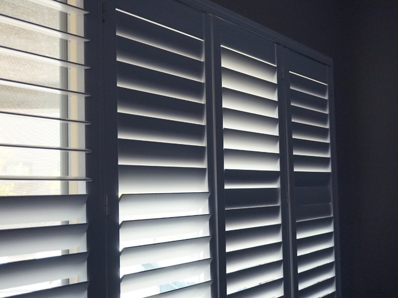 interior aluminium shutters in a dark room with closed horizontal slats blocking light